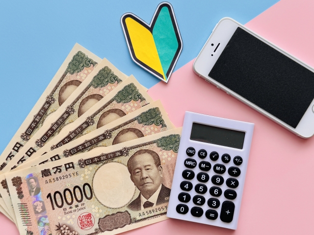 お金とスマートフォン、節約や経済圏の見直しをイメージした写真