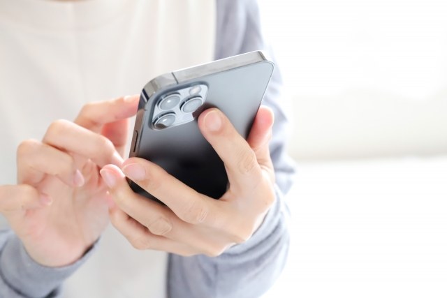 スマートフォンを持って格安SIMの料金を確認する様子