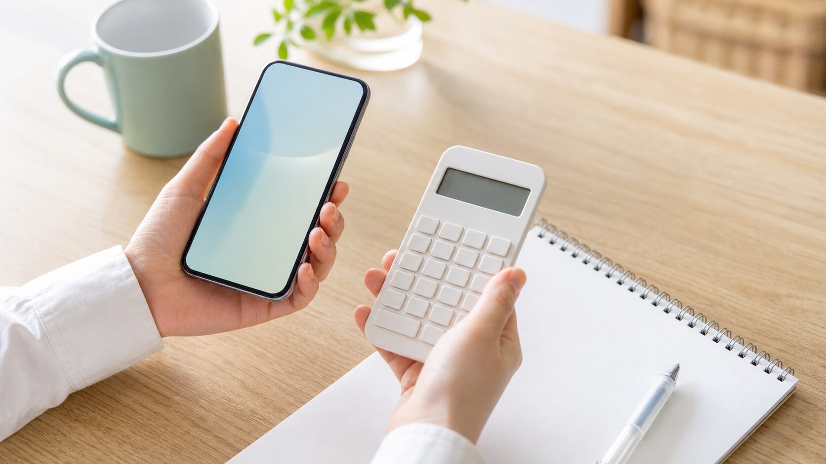 スマホと電卓で料金プランを見比べる手元
