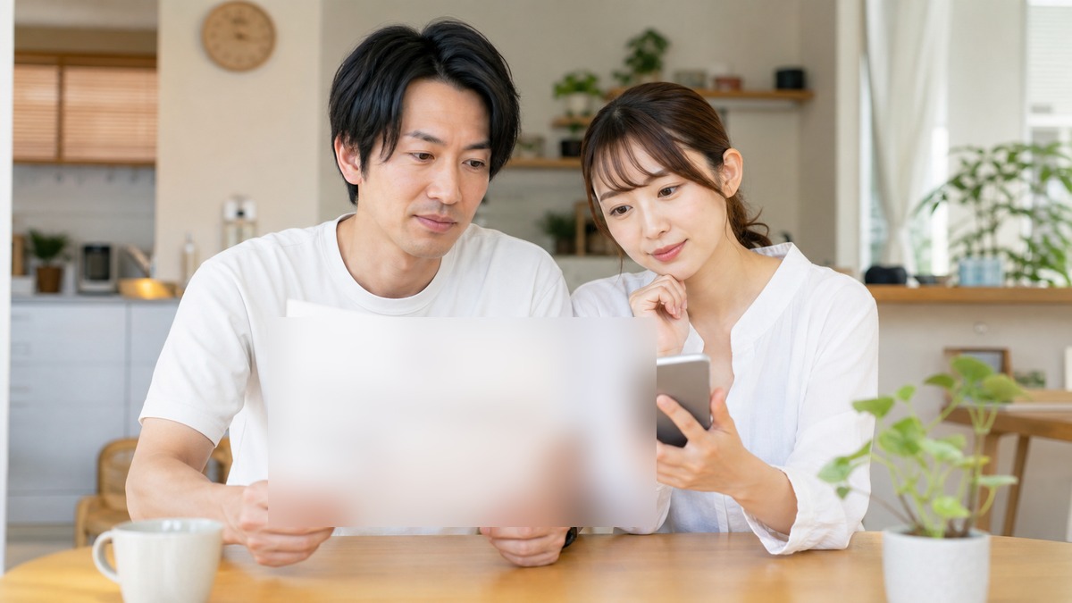 家計の明細を見ながら通信費を確認する夫婦