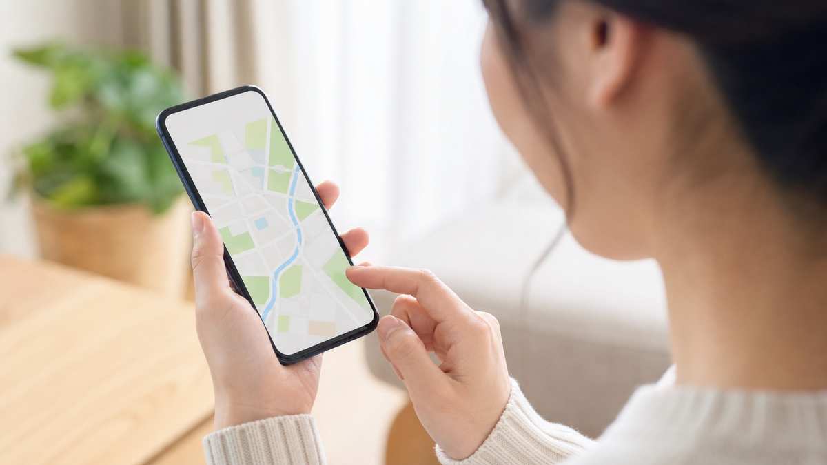 スマホで子供の居場所を見守る保護者の手元