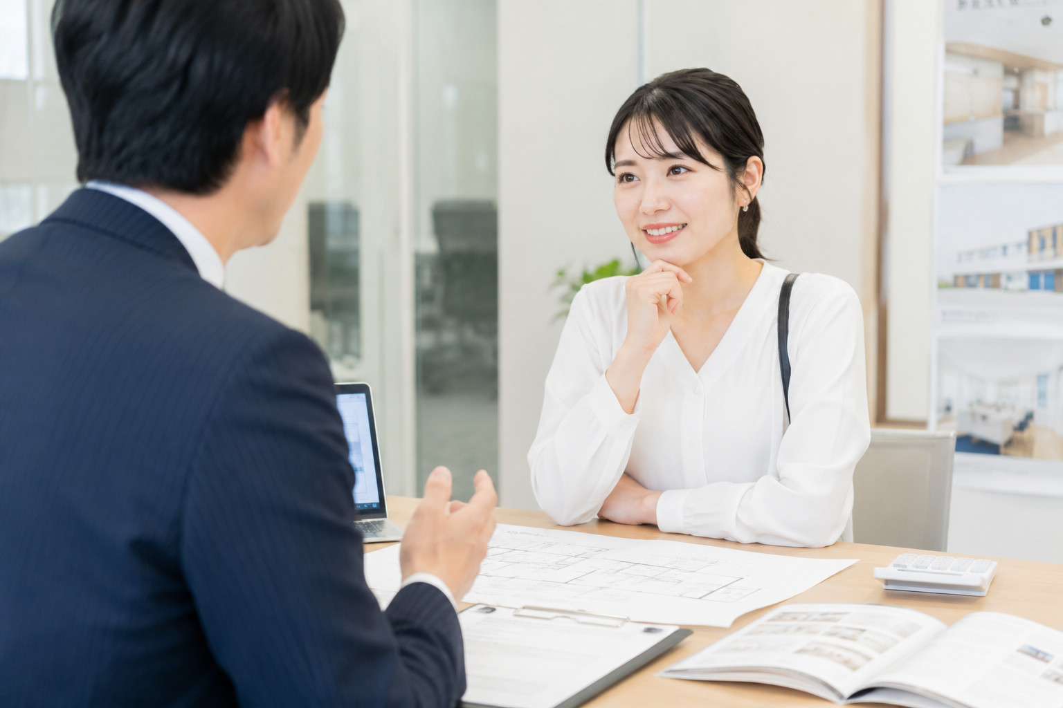 不動産オフィスで管理会社の担当者とNURO光導入について相談する女性