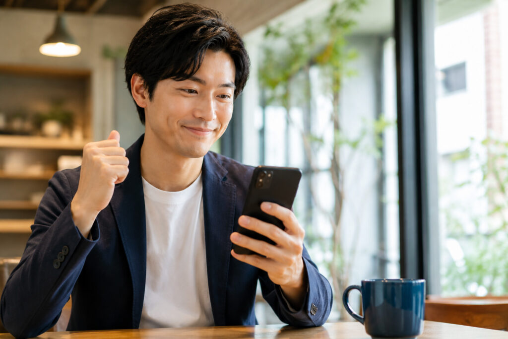 カフェで喜ぶ男性