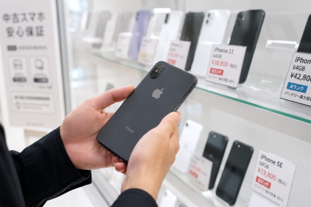 中古iPhoneショップで端末を手に取る様子