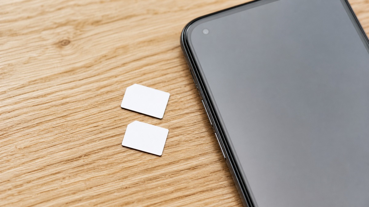 2枚のSIMカードとスマートフォンを机に並べた様子