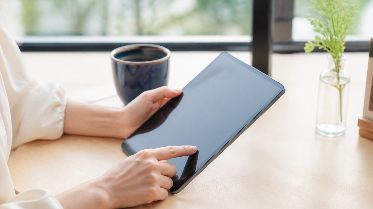 カフェで無地のタブレットを操作する手元