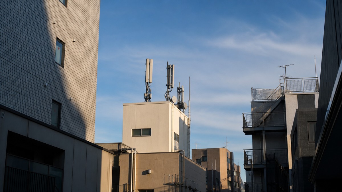 ビルが立ち並ぶ街並みと携帯電話の基地局アンテナ