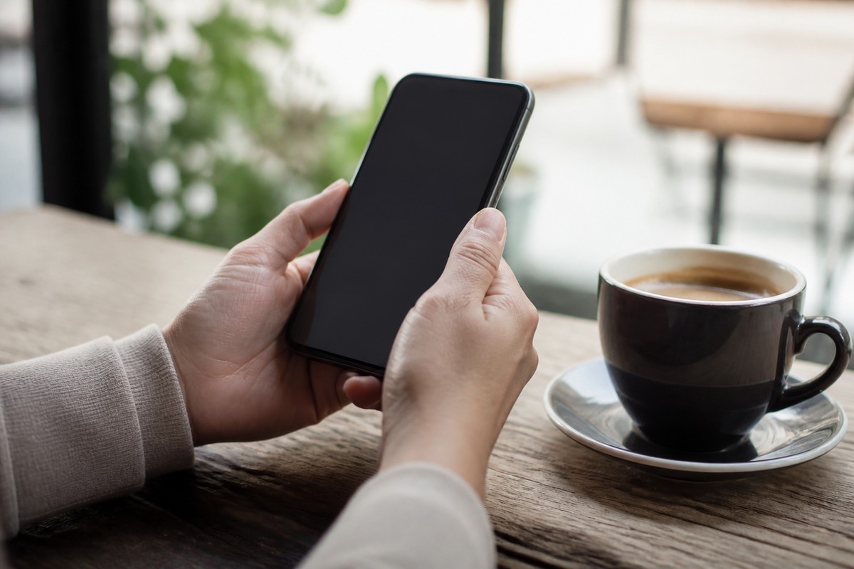 カフェでスマートフォンの口コミを確認する人の手元