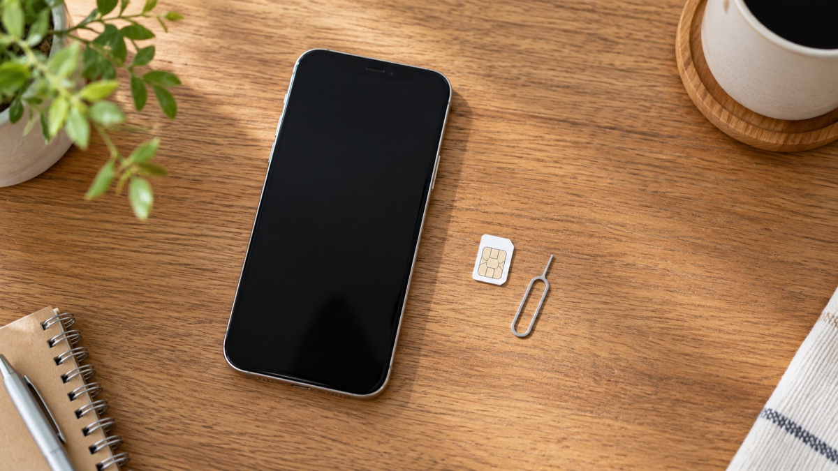 机に置いたスマートフォンとSIMカード